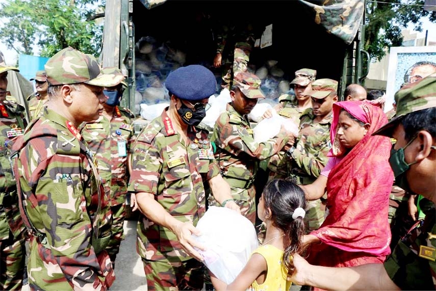 Chief of Army Staff General SM Shafiuddin Ahmed distributes relief items among the flood-hit people at Mayeenpur in Sunamganj on Thursday.