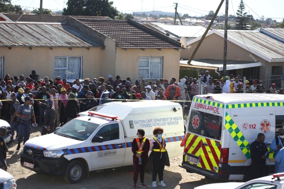 Crowd gathers as forensic personnel investigate after the deaths of patrons found inside the Enyobeni Tavern, in Scenery Park, outside East London in the Eastern Cape province, South Africa, June 26, 2022.