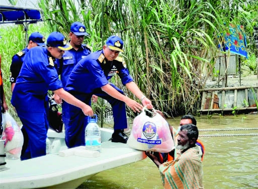 SUNAMGANJ : Members of Coast Guard distributes relief among the flood hits in Sumanganj on Sunday. Among others, Rear Admiral Ashraful Hoq Chowdhury, ndu, afwc, psc, Director General , Bangladesh Coast Guard was present there.