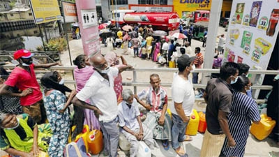 People stand in a long queue to buy kerosene oil for cookers amid a shortage of domestic gas due to country's economic crisis, at a fuel station in Colombo, Sri Lanka.