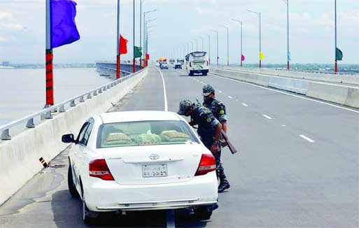 Army personnel frisk a private car on the Padma Bridge as part of security on Monday a day after it was opened for traffic. Agency photo