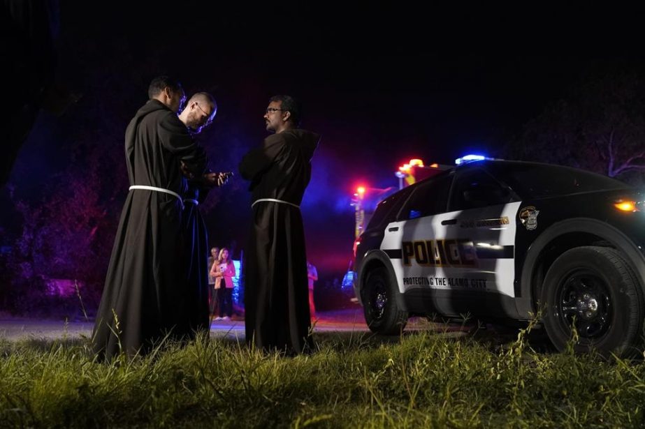 Priests gather near the scene where officials say dozens of people have been found dead and multiple others were taken to hospitals with heat-related illnesses.