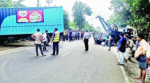 Onlookers stand in front of a covered van which ploughed through pedestrians in Raipura upazila under Narsingdi district on Thursday leaving five people dead.