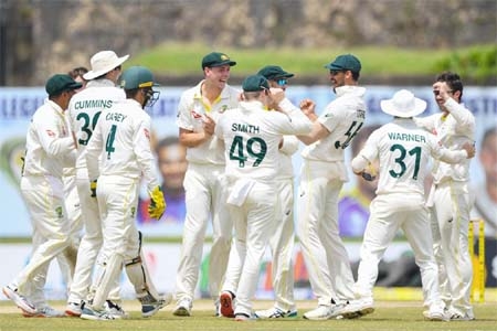 Australia's players celebrate after the dismissal of Sri Lanka's Oshada Piyumal Fernando (not pictured) during the third day of first cricket Test match between Sri Lanka and Australia at the Galle International Cricket Stadium in Galle on Friday.