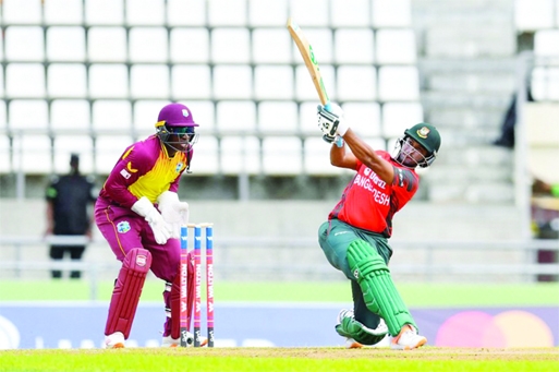Shakib Al Hasan (right) of Bangladesh plays a shot, while West Indies' wicketkeeper Nicholas Pooran watches during their second Twenty20 International match at the Windsor Park in Dominica on Sunday.