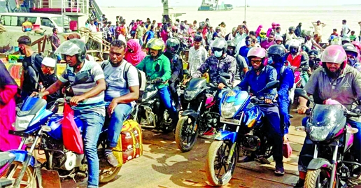 Defying government's ban commoners seen to go to their ancestral homes riding on their motorcycles. The snap was taken from Paturia in Manikganj on Friday.