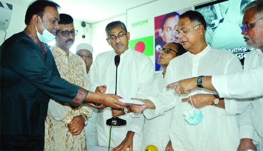 BNP Standing Committee Member Iqbal Hasan Mahmud Tuku receives grant aid for the flood affected people from Dhaka Mahanagar Uttar BNP at BNP Chairperson's political office in the city's Gulshan on Friday.
