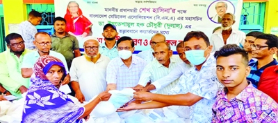 Bangladesh Medical Association's Chairperson Dr Ehteshamul Hoque Dulal on behalf of Prime Minister Sheikh Hasina distributes food stuffs among the needy people of Balaganj Sadar Union on Friday.
