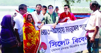 President of Sylhet 'Vivek' Jyotirmoy Singho Mazumder along with others distributes cash money among the flood victims in remote areas adjacent to Matian haor and Tanguar Haor in Tahirpur Upazila of Sunamganj on the eve of Eid-ul-Azha on Friday.