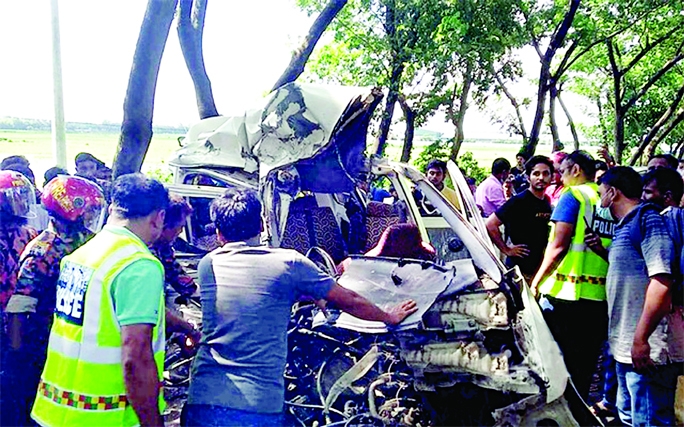 Onlookers stand in front of a smashed microbus after being collided head-on with a bus at Dargaghet area of Madhabpur upazila on Dhaka-Sylhet Highway on Monday leaving four people dead.