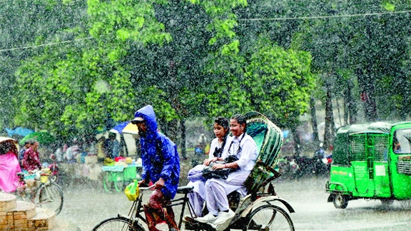 Two female students get drenched with rainwater on a rickshaw to relieve of excruciating heat. This photo was taken from TSC area in the capital on Monday morning.