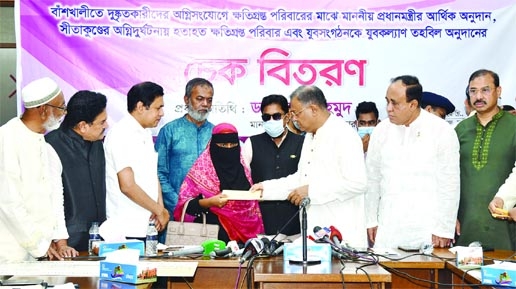 Information and Broadcasting Minister Dr. Hasan Mahmud hands over cheque of assistance among the affected families of fire incident in Sitakundo at Chattogram Circuit House on Friday.