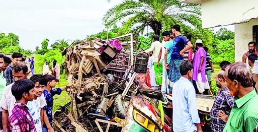 Inquisitive onlookers stand near a maimed passenger minibus at Maizpara rail crossing on Dhaka-Mymensingh Highway in Sreepur under Gazipur district on Sunday leaving four people dead.