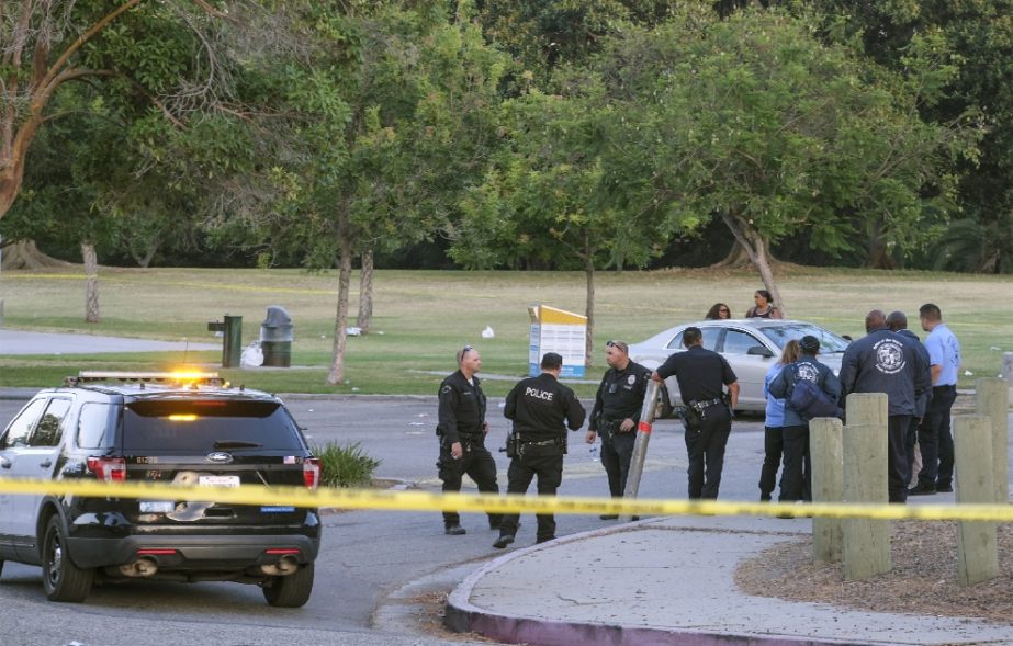 Police officers stand near the scene of a shooting at Peck Park in San Pedro, Calif., Sunday, July 24, 2022.