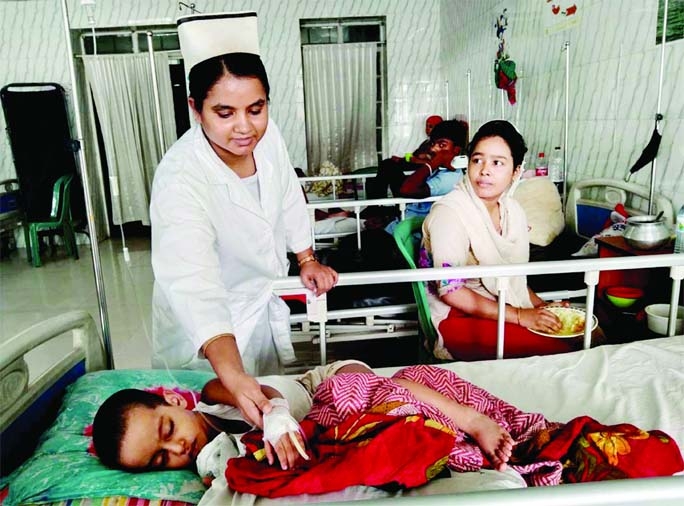 A nurse of Holy Family Hospital in the capital taking care of a dengue patient. Number of dengue patients is also increasing rapidly in different other city hospitals. This photo was taken from the Holy Family Hospital on Thursday.