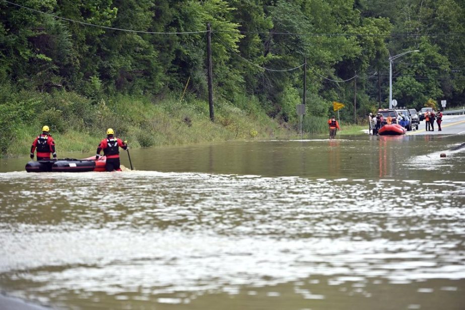 Members of the Winchester, Ky., Fire Department walk inflatable boats across flood waters over Ky. State Road 15 in Jackson, Ky., to pick up people stranded by the floodwaters Thursday, July 28, 2022.