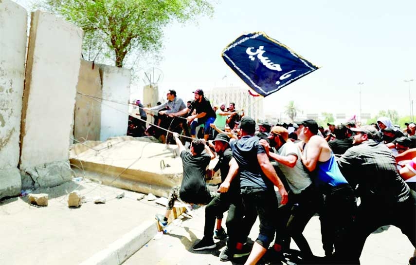 Supporters of Iraq's influential Sh ia leader Muqtada al-Sadr bring down concrete barriers surrounding the high-security Green Zone in Baghdad on Saturday. Agency photo