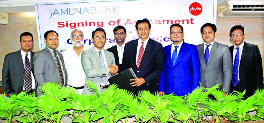 AKM Saifuddin Ahamed, DMD of Jamuna Bank Limited and Morshedul Alam Chaklader, CEO of Air Asia Airlines, exchanging an agreement signing documents at the bank's head office in the city recently. Under the deal, all employees and Credit Card holders of th