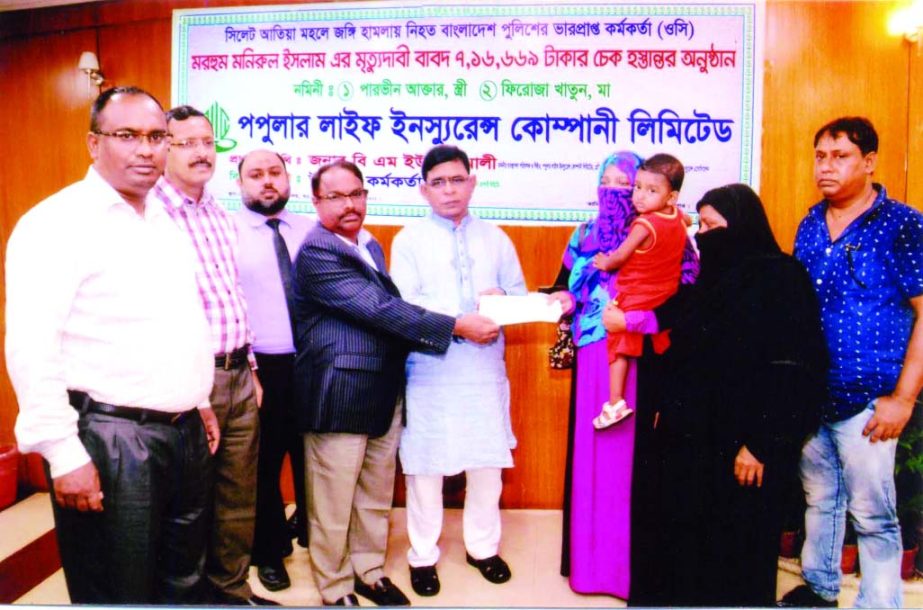 BM Mojammel Huq MP and BM Yusuf Ali, MD, Popular Life Insurance Company distributing policy claim money to the nominees of police officer late Monirul Islam, who was killed in Atia Mohal terrorist attack in Sylhet at the head office recently.