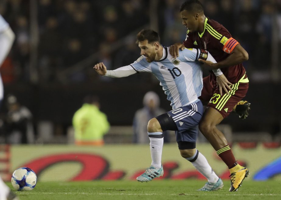 Argentina's Lionel Messi tries to reach the ball as he is grabbed by Venezuela's Salomon Rondon during a 2018 World Cup qualifying soccer match in Buenos Aires, Argentina on Tuesday.
