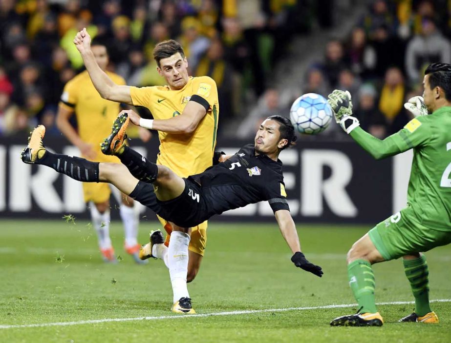 Australia's Tomi Juric (left) attempts goal against Thailand's Adisorn Promrak (center) and Sinthaweechai Hathairattanakool (right) and during their World Cup Group B qualifying soccer match in Melbourne, Australia on Tuesday.