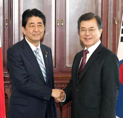 Japanese Prime Minister Shinzo Abe and South Korean President Moon Jae-in shake hands before their bilateral meeting in Vladivostok, Russia on Thursday.