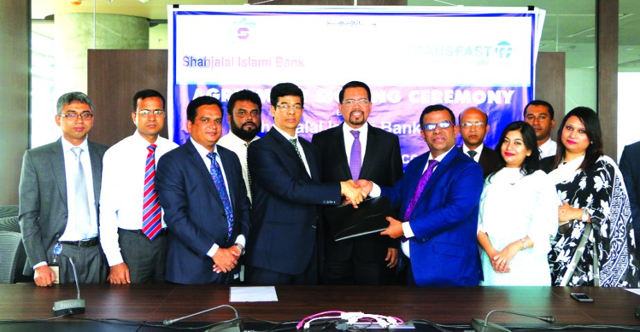 M Akhter Hossain, Deputy Managing Director of Shahjalal Islami Bank Limited and Mohammad Khairuzzaman, Country Director of Bangladesh of TRANSFAST Remittance LLC, exchanging an agreement signing documents at the bank's head office in the city recently. F