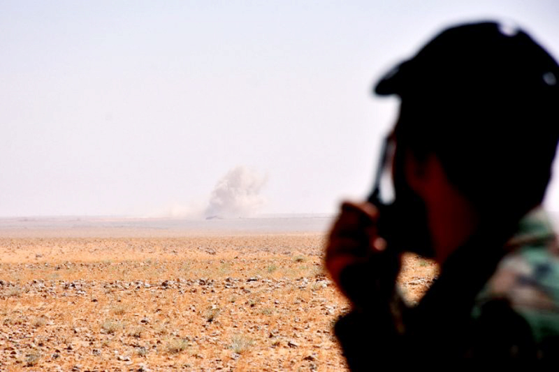 A member of the Syria government forces looks at smoke rising on the horizon on the outskirts of Deir Ezzor, on Thursday.