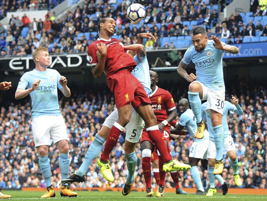 Manchester City's Nicolas Otamendi (right) and Liverpool's Joel Matip (center) go for a header during the English Premier League soccer match between Manchester City and Liverpool at the Etihad Stadium in Manchester, England on Saturday.