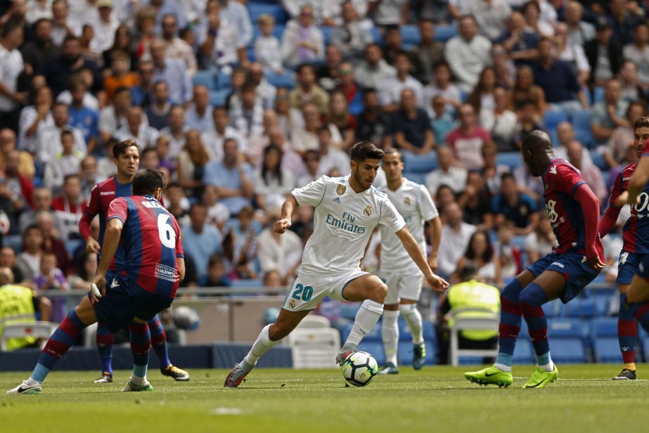 Real Madrid's Marco Asensio (center) controls the ball past Levante defenders during the Spanish La Liga soccer match between Real Madrid and Levante at the Santiago Bernabeu stadium in Madrid on Saturday.