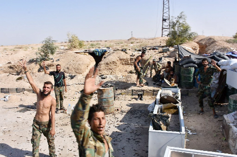 Syrian government forces flash the victory sign at a checkpoint on the outskirts of Deir Ezzor on Sunday.