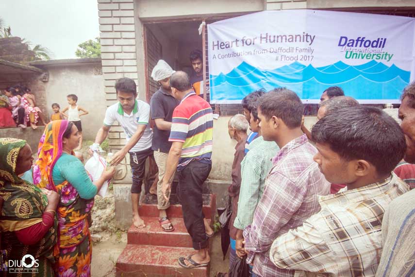 Students of Daffodil International University distributing relief goods among the flood affected people of Mohonpur Union under Dinajpur district as a part of the program title "Heart for Humanity"" recently."