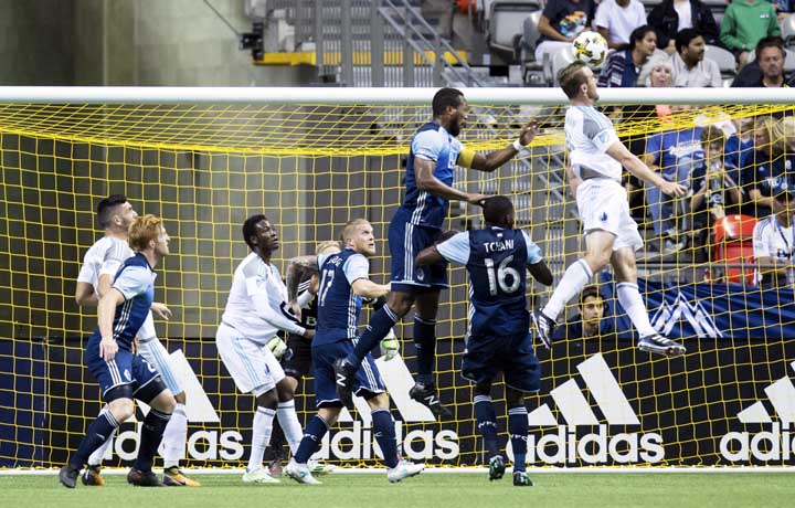 Minnesota United's Brent Kallman (right) gets his head on the ball on a corner kick in front of Vancouver Whitecaps' Tony Tchani (16) and Kendall Waston (third from right) but sends the ball wide of the net during the first half of an MLS soccer match o