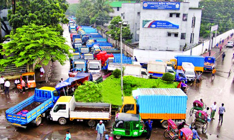 Transport owners and workers occupying Tejgaon Saat Rasta area have started parking trucks and covered van although Dhaka North City Corporation declared the area free from illegal parking. This photo was taken on Thursday.