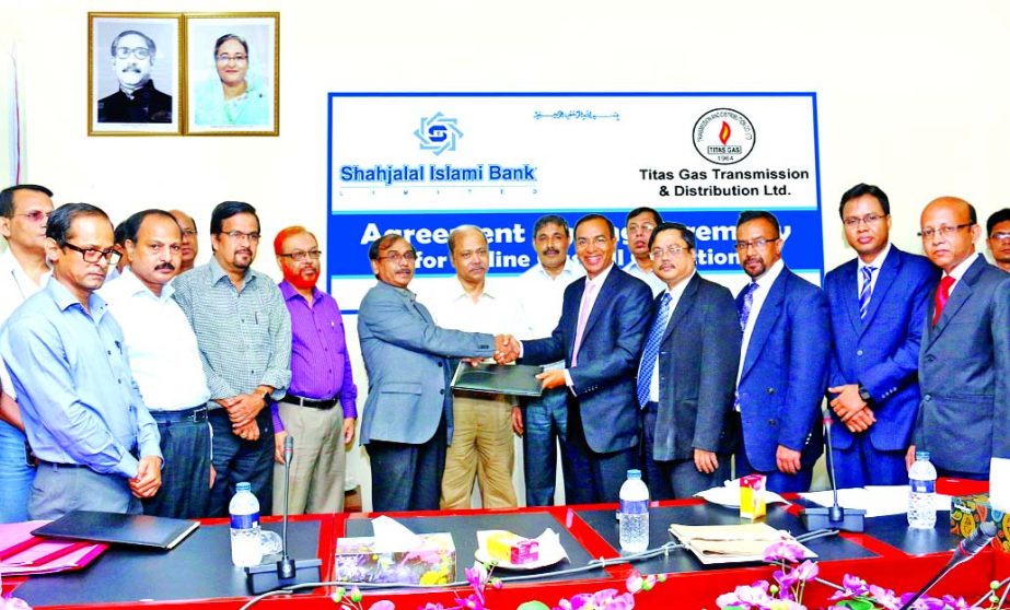 Engr. Mir Mashiur Rahman, Managing Director of TITAS GAS Transmission and Distribution Company Limited and M. Shahidul Islam, Additional Managing Director of Shahjalal Islami Bank Limited, exchanging an agreement signing documents at the bank's head offi