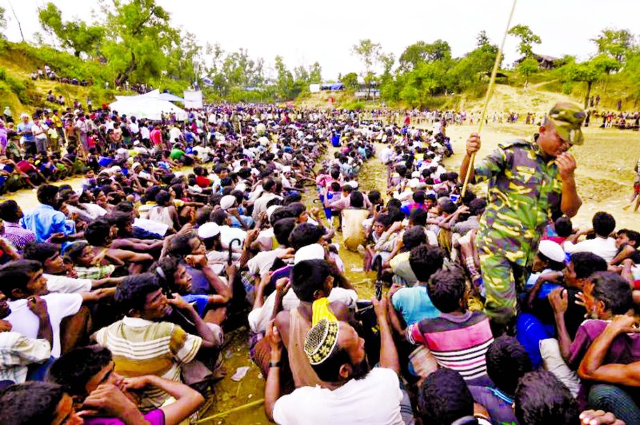 Rohingya Muslim refugees wait as food is distributed by the Bangladesh Army at Balukhali refugee camp near Gumdhum on Tuesday.