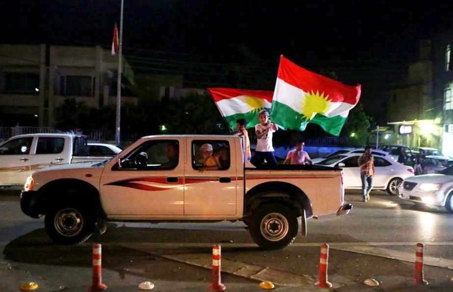 Iraqi Kurdish men celebrate as they wave Kurdish flags in the streets after the polls closed in the controversial Kurdish referendum on independence from Iraq, in Irbil, on Monday.