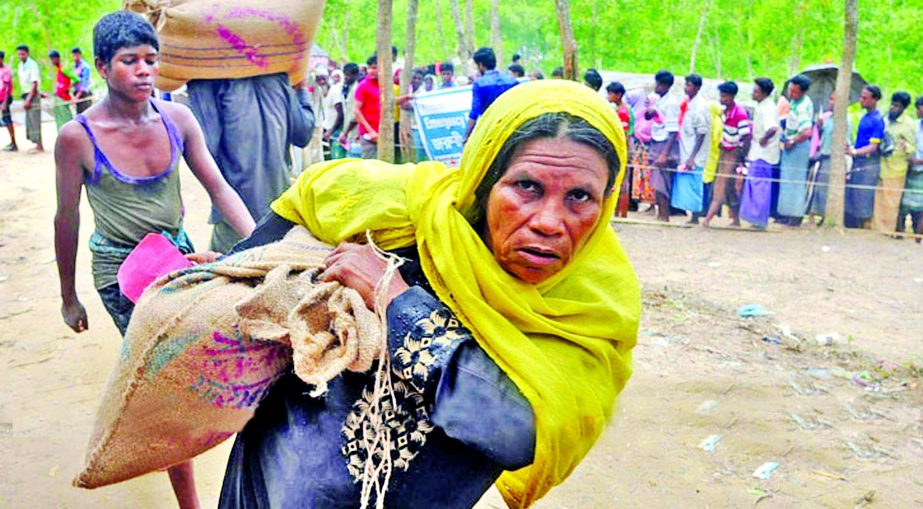 A Rohingya woman refugee carrying relief being distributed by the members of Bangladesh Armed Forces at Kutupalong camp on Thursday.