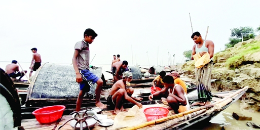 ISHWARDI (Pabna): Fishermen at Padma River ghat in Ishwardi Point depressed as they are not getting enough fishes. The picture was taken on Sunday.