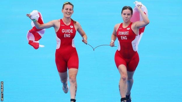 Guide Jessica Fullagar (left) and Katie Crowhurst of England celebrate winning gold in the women's PTVI Triathlon of the Commonwealth Games at Birmingham in England on Sunday. Agency photo