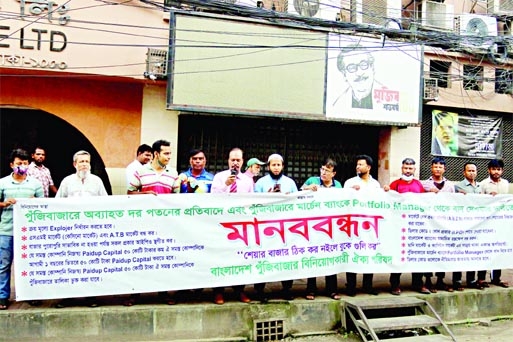 Share market investors form a human chain in front of Dhaka stock exchange on Monday, protesting continuous fall in share prices.