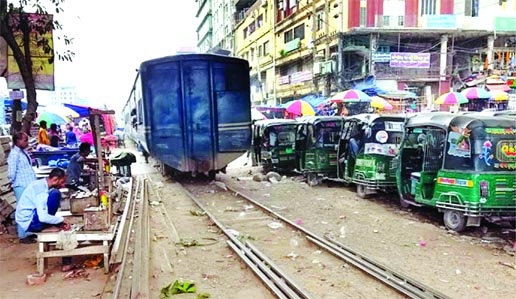 A train moves on a rail track at Jurain rail crossing on Friday leaving risks to people working in illegal makeshift shops around the rail lines.