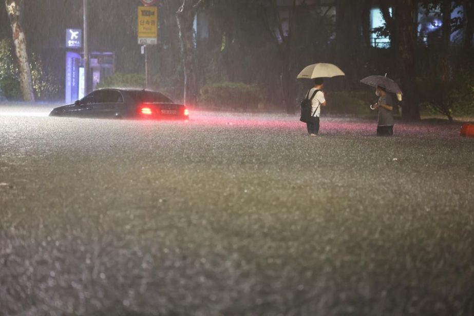 A vehicle is submerged in a flooded road in Seoul, Monday, Aug. 8, 2022.