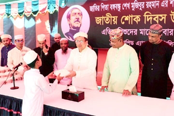DG Of RAB Abdullah Al Mamun distributes food items among destitute at RAB Headquarters in the city on Friday marking National Mourning Day.