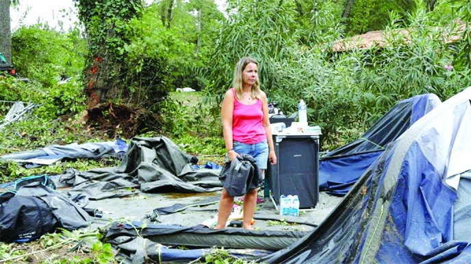 Holidaymaker packs what is left of their destroyed tents by storm and other items at the Sagone camping site in Corsica, France on Friday.