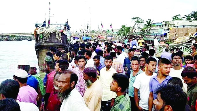 People wait at Alipur-Mohipur fisheries port in Patuakhali district on Sunday, as missing fishermen were retrieved.