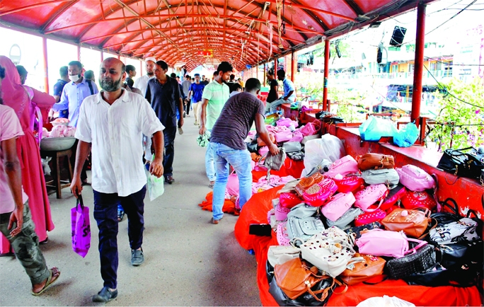 The temporary shops installed by the hawkers are seen at the Gausia New Market foot-over-bridge in the capital causing huge discomfort to the commuters. The photo was taken on Monday.