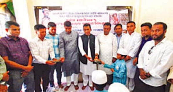 Mayor of Raozan Pourasava Jamiruddin Parvez seen distributing cooked foods among needy and destitute people on the occasion of doa mahfil in memory of 21 August grenade attack.
