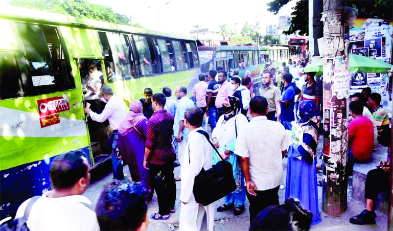Commuters swarm at G.P.O intersections in the capital on Wednesday to board on buses on the first day of new office schedule.