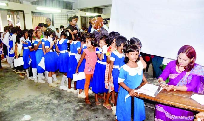 Children aged 5-11 years stand in a long queue at the Azimpur Model Govt. Primary School in order to receive Pfizer Covid-19 vaccine. The photo was taken on Thursday.